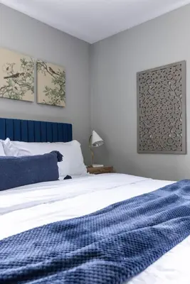 a bedroom with a bed with a blue headboard at Westlake Elegance - Detroit Unit 3 in Westlake