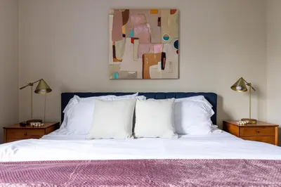 a bed with white pillows and a painting on the wall at Maple Heights Bliss - Unit 12 in Maple Heights
