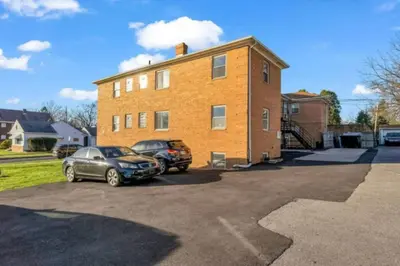 two cars parked in a parking lot in front of a building at Maple Heights Bliss - Unit 12 in Maple Heights
