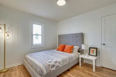 a bedroom with a bed with orange pillows and a window at Tranquil Fort Wayne Home 7 Mi to Downtown in Fort Wayne