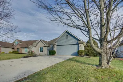 a house with a tree and a driveway at Tranquil Fort Wayne Home 7 Mi to Downtown in Fort Wayne
