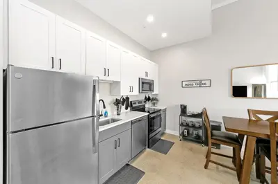 a kitchen with a stainless steel refrigerator and a table at King Bed, Downtown Steps from Bengals & Reds, Minutes to OTR, TQL, HardRock in Cincinnati