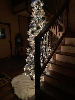a staircase with a christmas tree with lights at Lakeside Cabin Hot tub close to Ark Encounter in Corinth