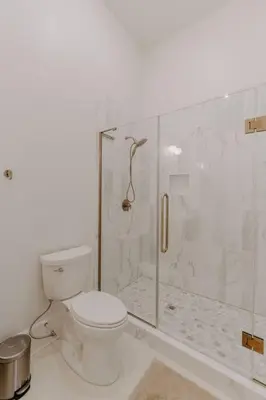 a bathroom with a toilet and a glass shower at East Main Lofts - Minimalist 302 in Madison