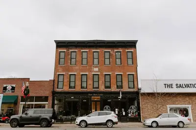 two cars parked in front of a brick building at East Main Lofts - Minimalist 302 in Madison