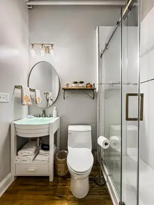 a bathroom with a toilet and a sink and a mirror at The Historic Lyric Presidential Suite in Cincinnati