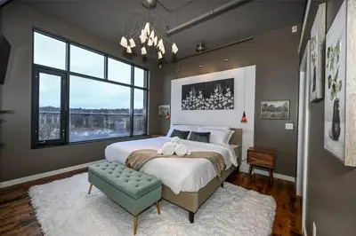 a bedroom with a large bed and a large window at Luxury Condo in Akron Northside District in Akron
