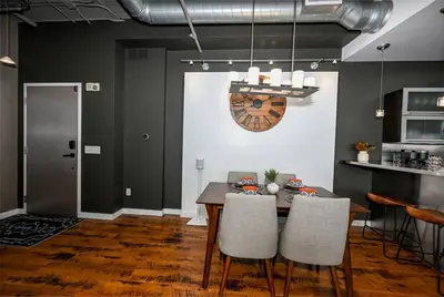 a dining room with a table and a clock on the wall at Luxury Condo in Akron Northside District in Akron