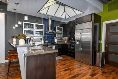 a kitchen with a stainless steel refrigerator and cabinets at Luxury Condo in Akron Northside District in Akron