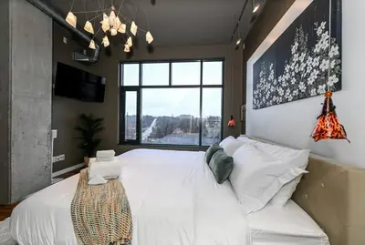 a bedroom with a large white bed and a window at Luxury Condo in Akron Northside District in Akron