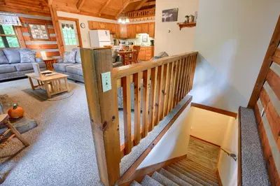 a living room with a staircase in a cabin at Chickasaw in Logan