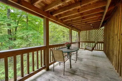 a screened in porch with a table and chairs on it at Chickasaw in Logan
