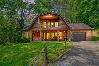 a large house with a porch and a garage at Lakewood Cottage in Logan