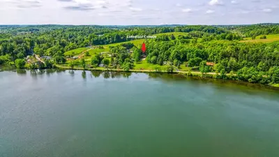 an aerial view of a lake with trees and houses at Lakewood Cottage in Logan