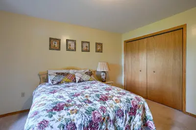 a bedroom with a bed and a wooden closet at Lakewood Cottage in Logan