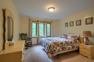 a bedroom with a bed and a desk and a window at Lakewood Cottage in Logan