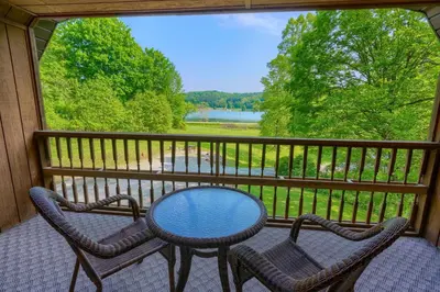 a table and two chairs on a balcony with a view at Lakewood Cottage in Logan
