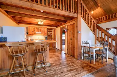 a kitchen with wooden floors and a counter with bar stools at Shawnee in Logan
