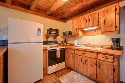 a kitchen with a white refrigerator and wooden cabinets at Shawnee in Logan