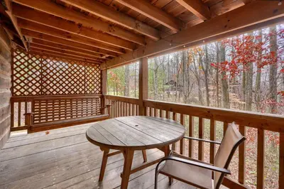 a wooden porch with a wooden table and a chair at Shawnee in Logan
