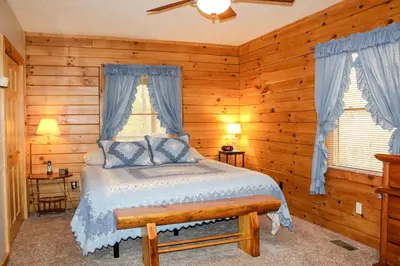 a bedroom with a bed in a log cabin at Dewdrop Inn in Logan