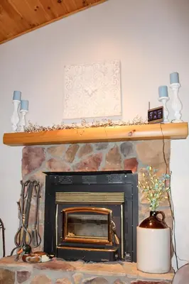 a fireplace with a shelf on top of it at Dewdrop Inn in Logan