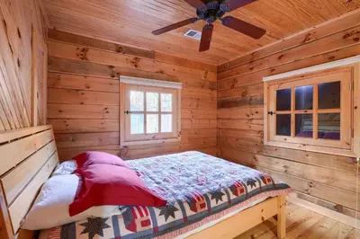 a bedroom with a bed in a log cabin at Bison Hollow Hideaway in South Bloomingville