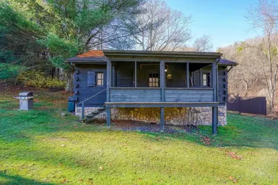 a small house sitting on a grass field at Bison Hollow Hideaway in South Bloomingville