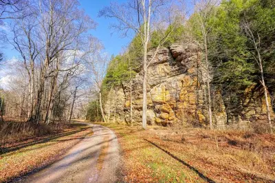 a dirt road next to a rock wall at Bison Hollow Hideaway in South Bloomingville