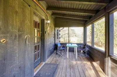 a porch of a house with a table and chairs at Bison Hollow Hideaway in South Bloomingville