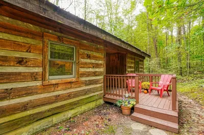 a wooden cabin with two chairs on a porch at Cherokee in Logan