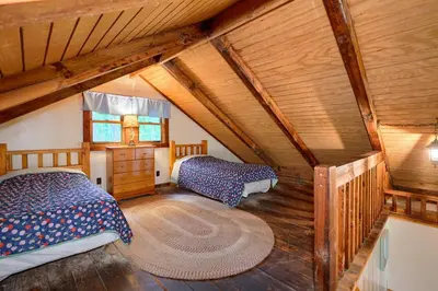 two beds in a room with wooden ceilings at Cherokee in Logan