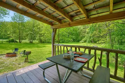 a picnic table on the deck of a cabin at Cypres Caban in Logan