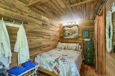 a bedroom with a bed in a log cabin at Cypres Caban in Logan