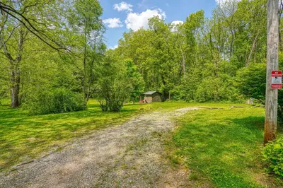 a dirt road in a field with a house in the background at Cypres Caban in Logan