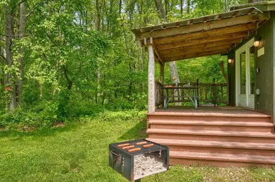 a small cabin with a porch and a deck at Cypres Caban in Logan