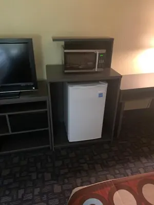 a room with a microwave and a small refrigerator at Super 8 by Wyndham Port Clinton in Port Clinton