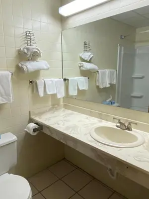 a bathroom with a sink and a mirror and a toilet at Super 8 by Wyndham Port Clinton in Port Clinton