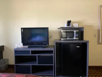 a room with a tv on a stand with a microwave at Super 8 by Wyndham Port Clinton in Port Clinton