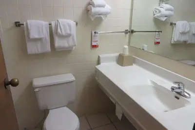 a bathroom with a sink and a toilet and a mirror at Super 8 by Wyndham Port Clinton in Port Clinton