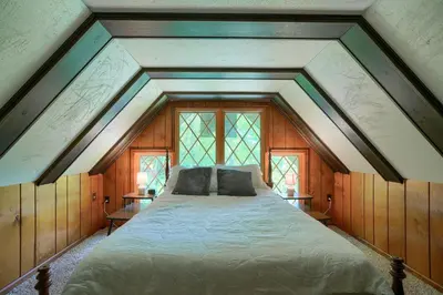 a large bed in a room with windows at Mercer House in Sugar Grove
