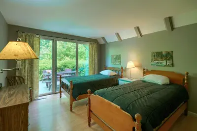 a bedroom with two beds and a sliding glass door at Mercer House in Sugar Grove