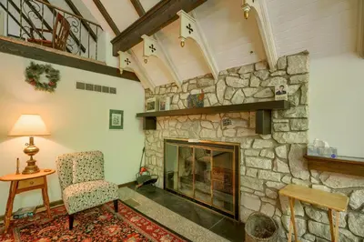 a living room with a stone fireplace and a chair at Mercer House in Sugar Grove
