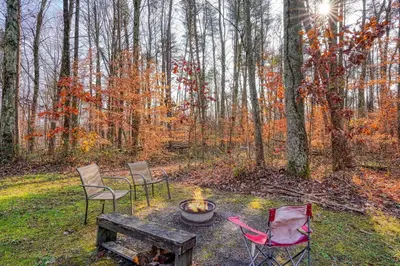 three chairs and a fire pit in the woods at Navajo in Logan