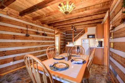 a dining room with a table and wooden walls at Navajo in Logan