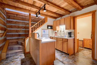 a kitchen with wooden cabinets and a staircase at Navajo in Logan