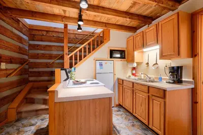 a kitchen with wooden cabinets and a staircase at Navajo in Logan
