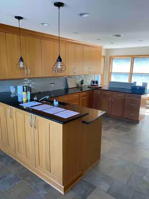 a kitchen with wooden cabinets and a counter top at Lakeside resort home. Sunsets, fishing, paddling. in Avon Lake