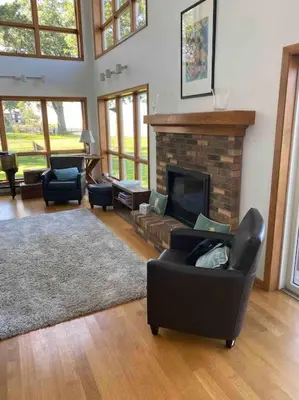 a living room with a couch and a fireplace at Lakeside resort home. Sunsets, fishing, paddling. in Avon Lake