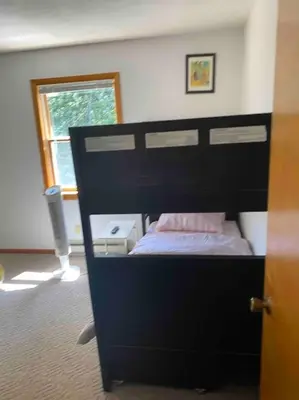 a bedroom with a bed with a black headboard at Lakeside resort home. Sunsets, fishing, paddling. in Avon Lake